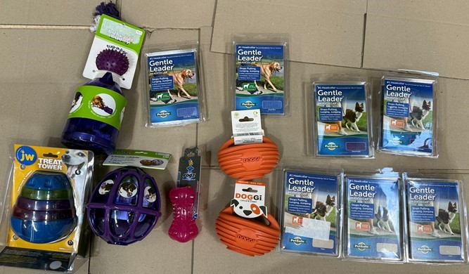 Assorted Dog Accessories: Mix of Dog Toys and Gentle Leader harnesses.